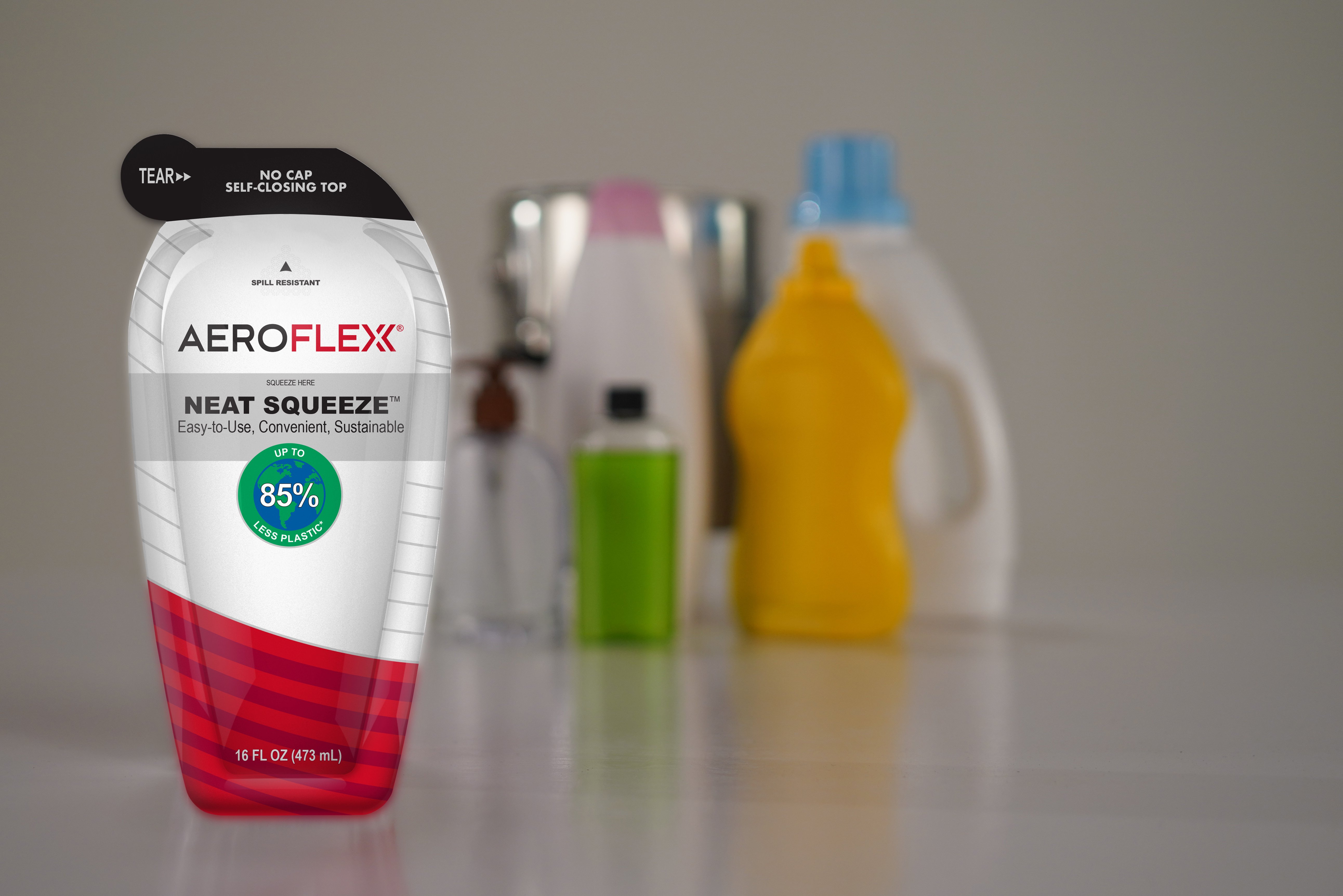 A flexible white and red AeroFlexx pouch in front of several blurred plastic bottles.