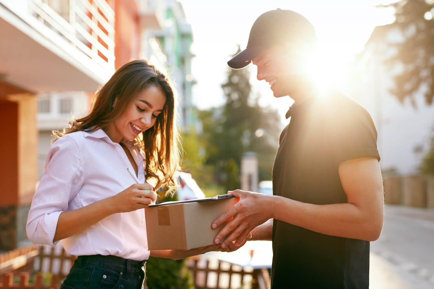 Woman signing for a package from a delivery person