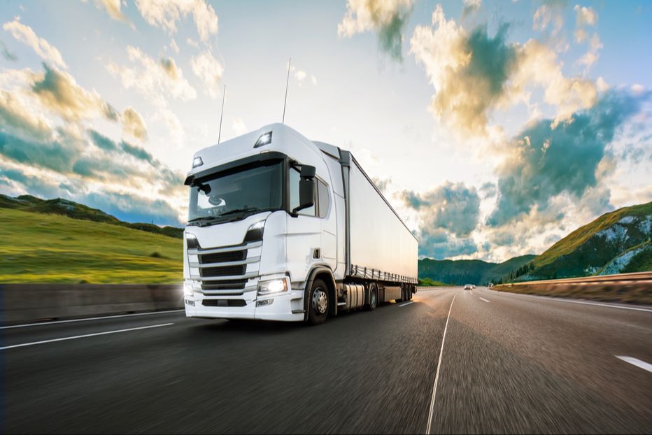 A tractor trailer driving down the road