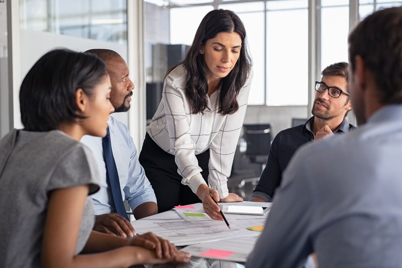 Employee presenting a proposal to a group sitting around a conference table