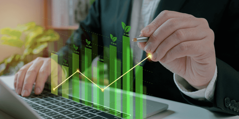 Person in a suit interacting with a digital green bar graph on a laptop.