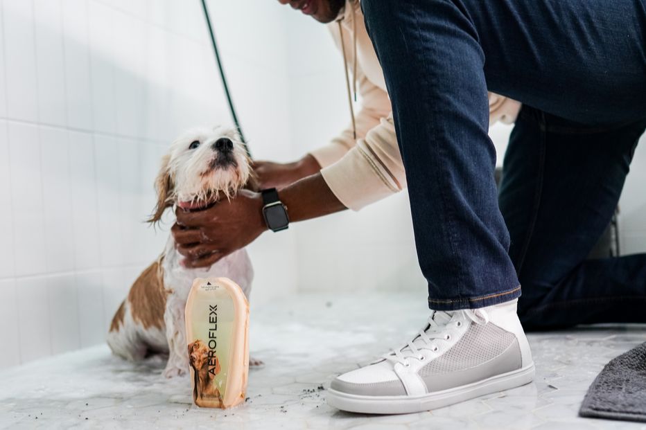 Man bathing dog with pet shampoo in an AeroFlexx Pak