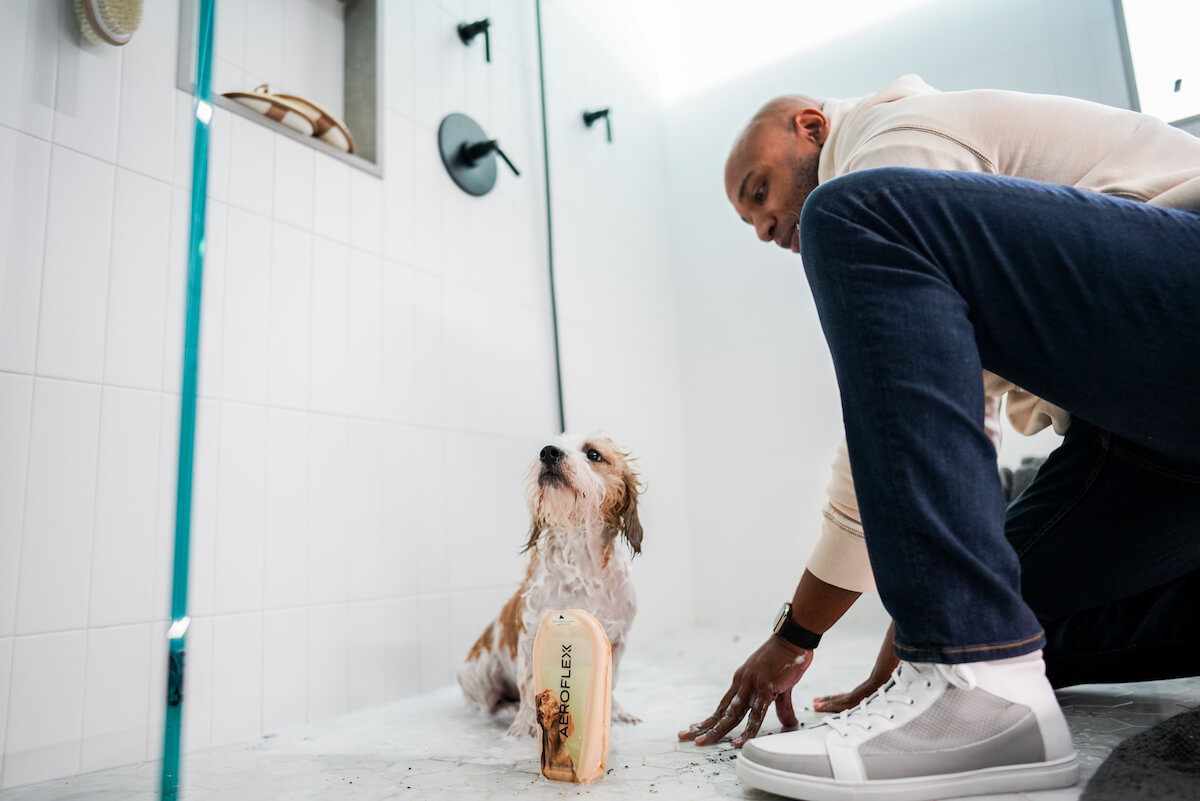 Man bathing dog with pet shampoo in an AeroFlexx Pak