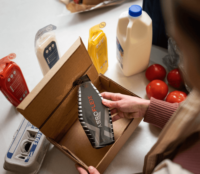 Person opening a box containing an AeroFlexx Pak